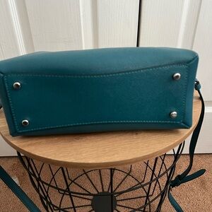 Teal color Coach handbag with cross body strap.